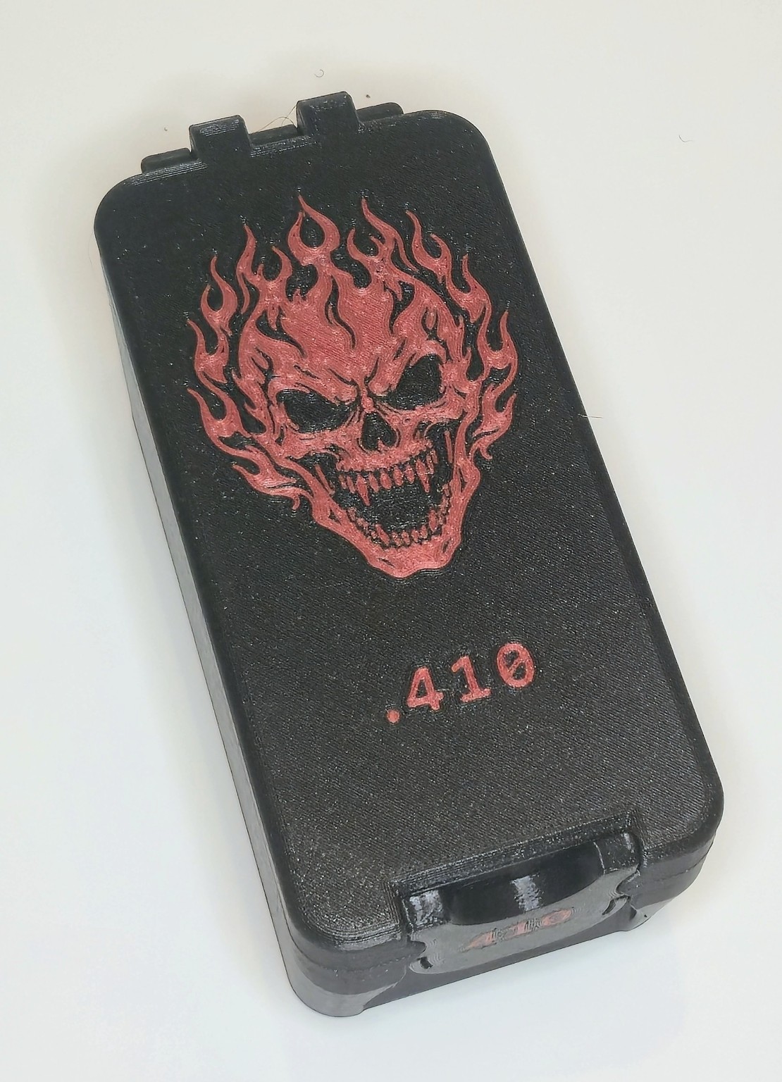 Closed custom black .410 box with dark red flaming skull graphic